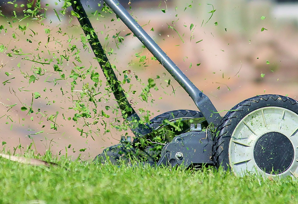 Push mower mowing lawn.